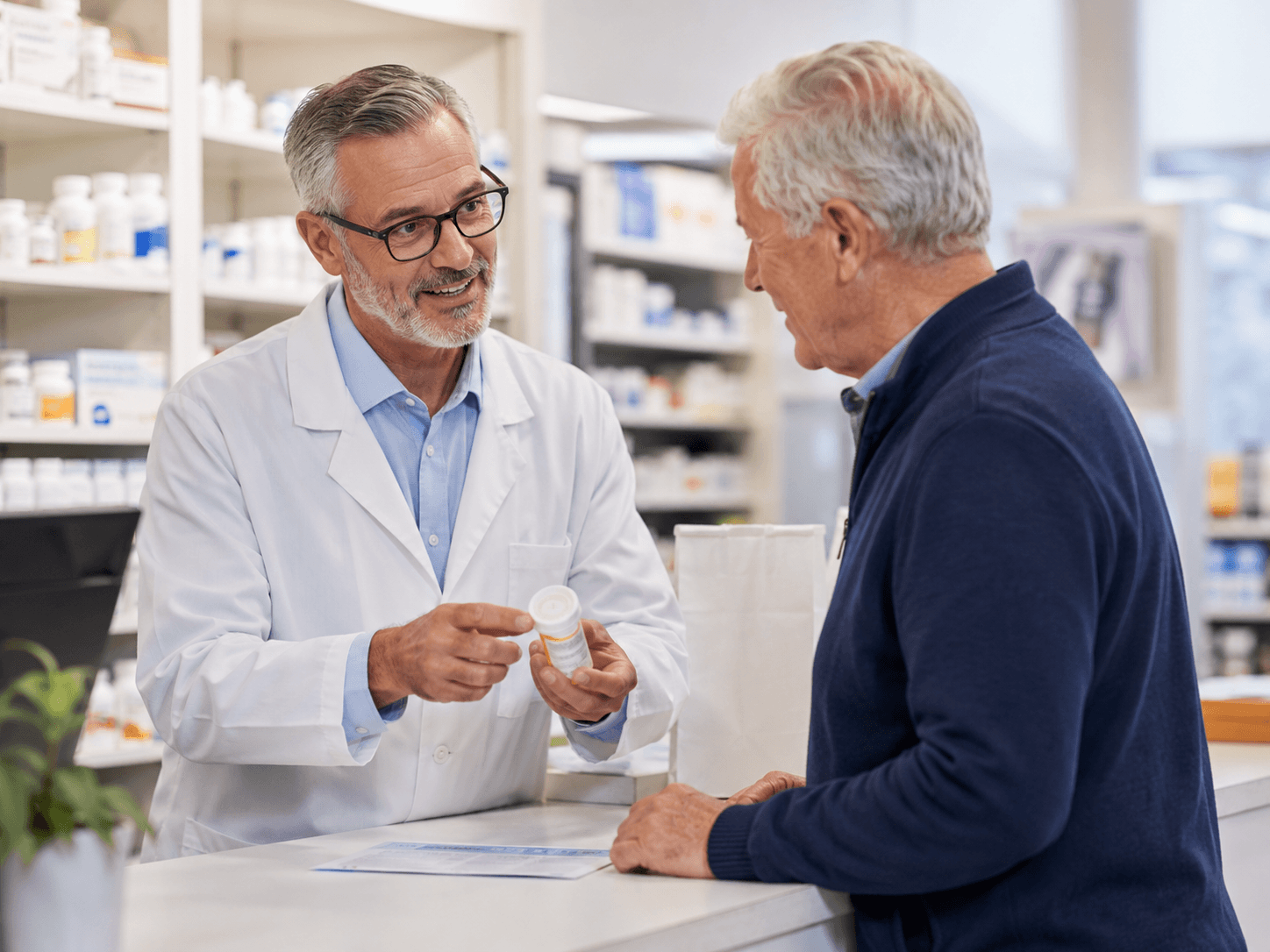 A pharmacist explaining a prescription to an older adult at the pharmacy counter